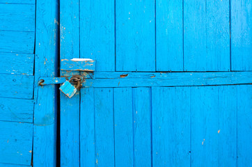 Rusty padlock on old wooden gate