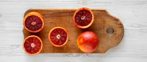 Blood oranges on rustic wooden board on a white wooden surface, top view. Flat lay, overhead, from...