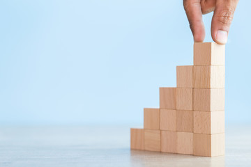 Fototapeta premium Hand Closer up hands of businessmen,stacking wooden blocks into steps,Concept of business growth success