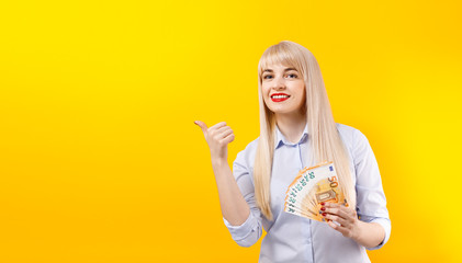 Female hands with euro banknotes. Portrait of a cheerful young blonde girl holding money .