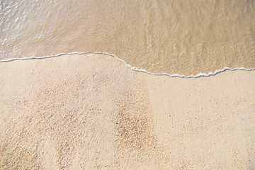 Close Up soft wave flow beautiful ocean on sandy beach. Background. sunshine in the evening. top view.