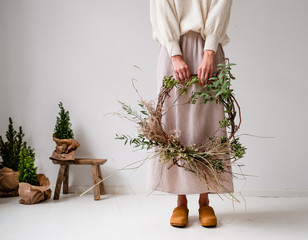 Frau hält Kranz für Weihnachten in der Hand