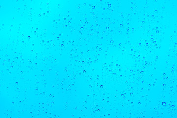 Rain drops on the blue glass, background.