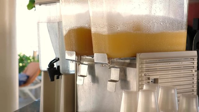 Dispensers making orange juice at hotel bar, nobody