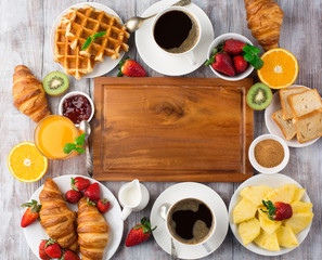 Continental breakfast table with coffee, orange juice, croissants