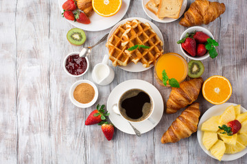 Continental breakfast table with coffee, orange juice, croissants