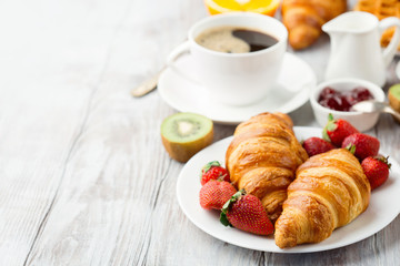 Continental breakfast table with coffee, orange juice, croissants