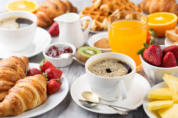 Continental breakfast table with coffee, orange juice, croissants - obrazy, fototapety, plakaty