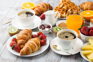 Continental breakfast table with coffee, orange juice, croissants