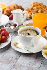 Continental breakfast table with coffee, orange juice, croissants