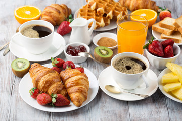 Continental breakfast table with coffee, orange juice, croissants