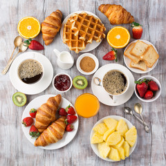 Continental breakfast table with coffee, orange juice, croissants