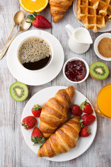 Continental breakfast table with coffee, orange juice, croissants