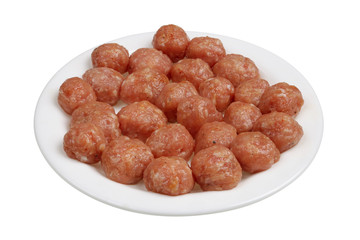 Small raw pork meatballs for meat soup are on the plate isolated macro
