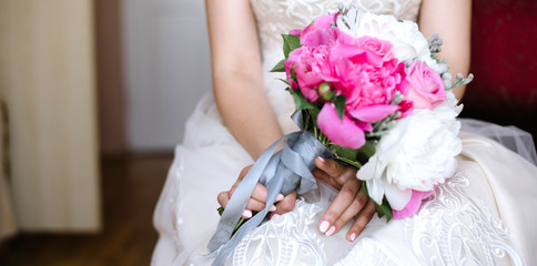 Obraz na płótnie Canvas The bride holds a wedding bouquet, close up
