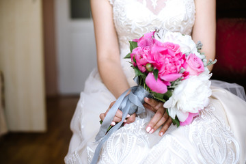 Obraz na płótnie Canvas The bride holds a wedding bouquet, close up