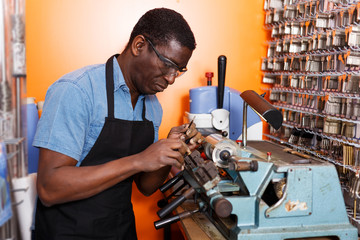 Professional skilled key cutter making duplicates of door keys