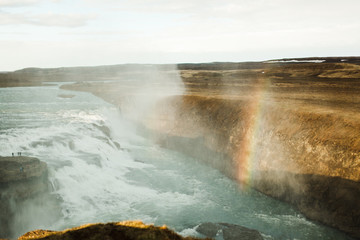  Rainbow over Icelandic waterfall in summer. Beautiful splashes and water vapor over a wild waterfall