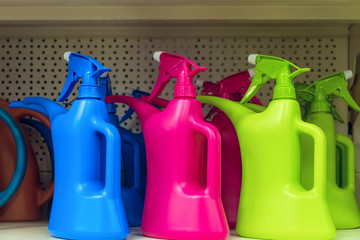 Colored plastic watering spray cans on the shelf