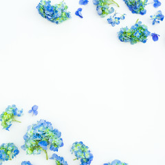 Floral frame of blue hydrangea flowers on white background. Flat lay, top view.