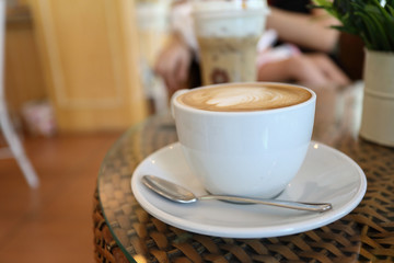 white cup of hot coffee drink put on table in cafe restaurant