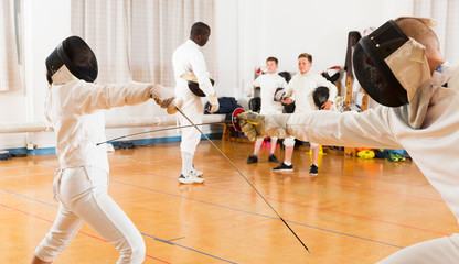 Young fencers training with coach