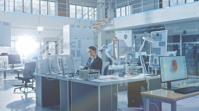 Time-Lapse of the Bright Industrial Robotics Technology and Design Office where People Work on Computer, Program and Manipulate Robot Arm. Engineers Working in Research Facility