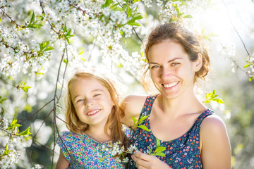 Fototapeta premium Mother and daughter in spring cherry blossom park
