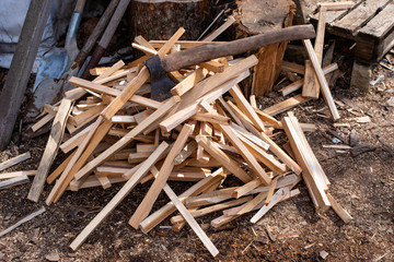Brown ax lies on a small pile of firewood, building materials