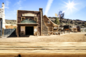 Wooden old table of free space for your product. Blurred background of Wild West city in America. 