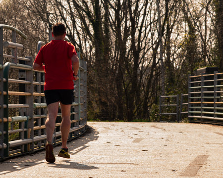 Runner in the parck over a bridge