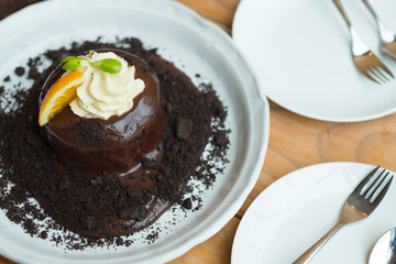 Chocolate lava cake with orange slice and whipping cream