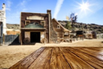 Wooden old table of free space for your product. Blurred background of Wild West city in America. 