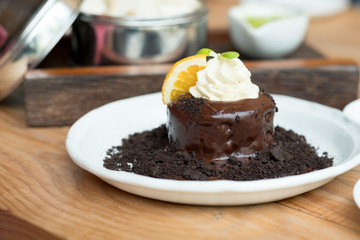 Chocolate lava cake with orange slice and whipping cream