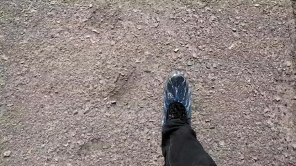 Top view of the feet of the guy who goes to the hospital in blue shoe covers