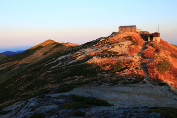 東北飯豊連峰　飯豊山山頂直下本山小屋の朝　朝陽に映える飯豊山山頂と本山小屋