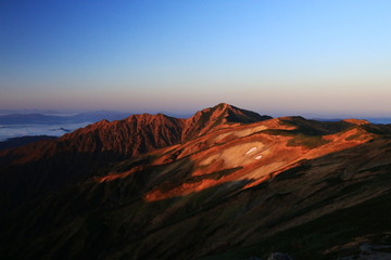 東北飯豊連峰　飯豊山山頂直下本山小屋の朝　朝陽に映える大日岳の雄姿と稜線