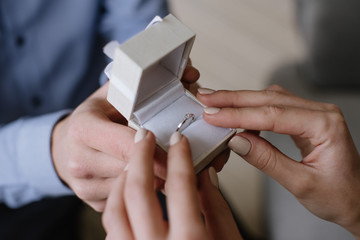 Men and women with proposal ring holding their hands. close up