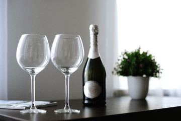 empty glasses and a bottle of wine or champagne on the table at
