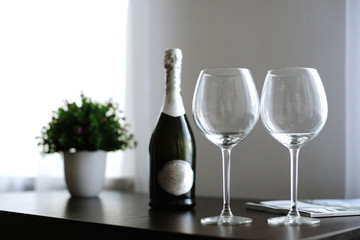 empty glasses and a bottle of wine or champagne on the table at