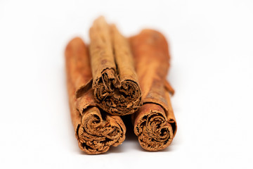 Isolated raw organic cinnamon sticks (Cinnamomum verum) from Sri Lanka. White background. Top front view. Selective focus.