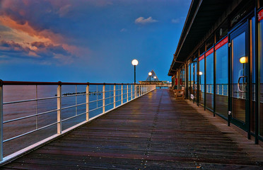 Obraz premium Wooden path and railing on the pier in Heringsdorf in the evening. Baltic Sea island Usedom. Germany