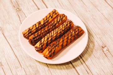 spanish fritters with chocolate served on a wooden table