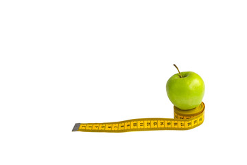 Green apple and measuring tape  with centimeters and inches isolated on white background.