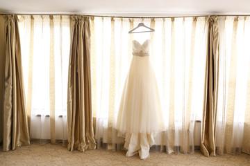 Wedding dress hanging by the window