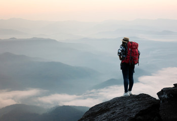 Backpack woman standing on the hill with beautiful nature background