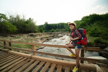 Fototapeta na wymiar Backpack woman on wooden bridge