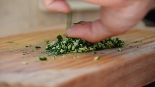 Man preparing Argentina traditional chimichurri, usually prepared and served with asado