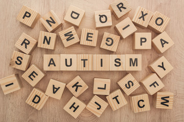 top view of autism lettering made of wooden blocks among another letters