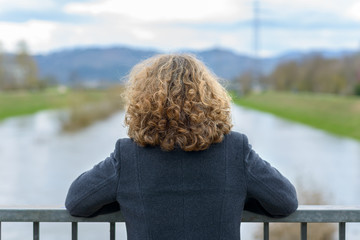 Woman with curly hair looking at the river